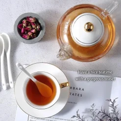 Elegantes Teeservice aus goldweißer Keramik mit Glasteekanne