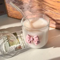 Rosa Kaffeetasse aus Glas mit Fliege, Deckel und Strohhalm – süßes Trinkgeschirr