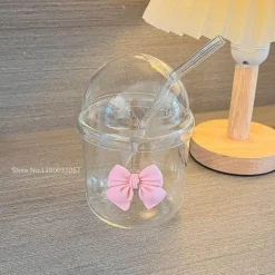 Rosa Kaffeetasse aus Glas mit Fliege, Deckel und Strohhalm – süßes Trinkgeschirr