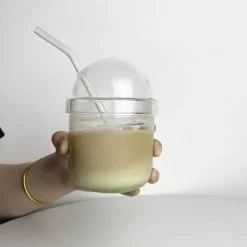 Rosa Kaffeetasse aus Glas mit Fliege, Deckel und Strohhalm – süßes Trinkgeschirr